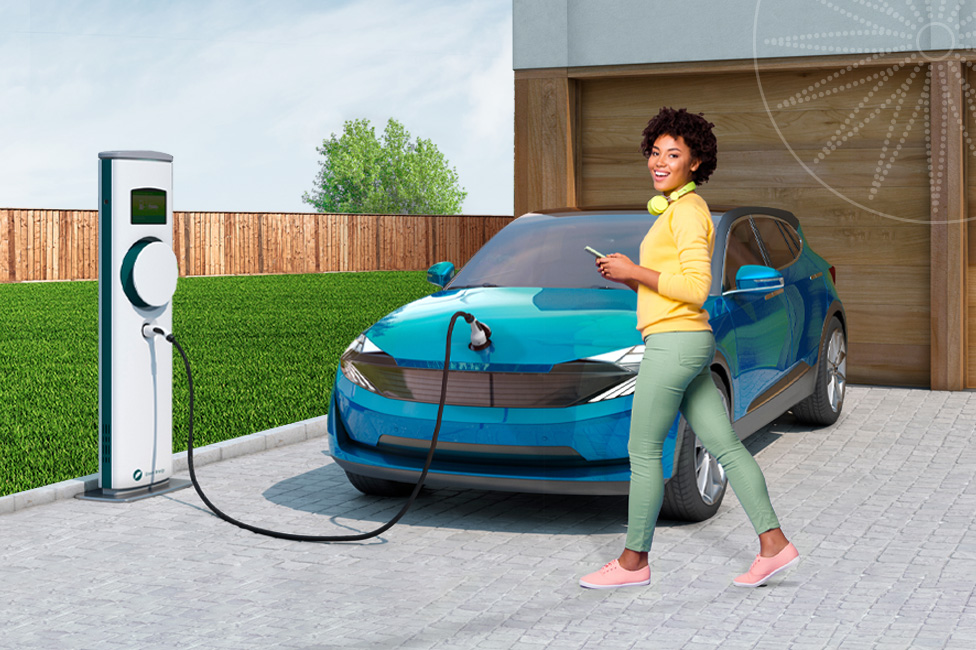 young woman standing in front of her electric car while it's charging